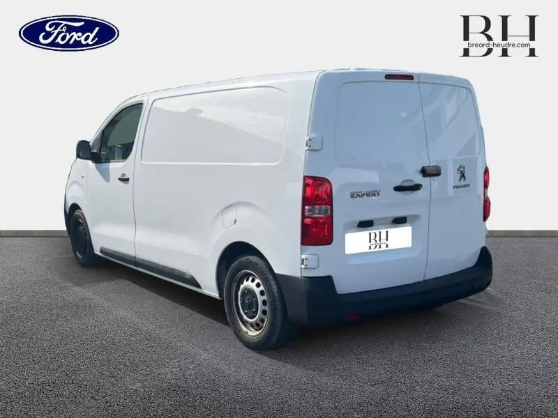 Vue 3/4 arrière droite d'un Peugeot Expert Fourgon blanc Banquise avec portes battantes et jantes acier noires.