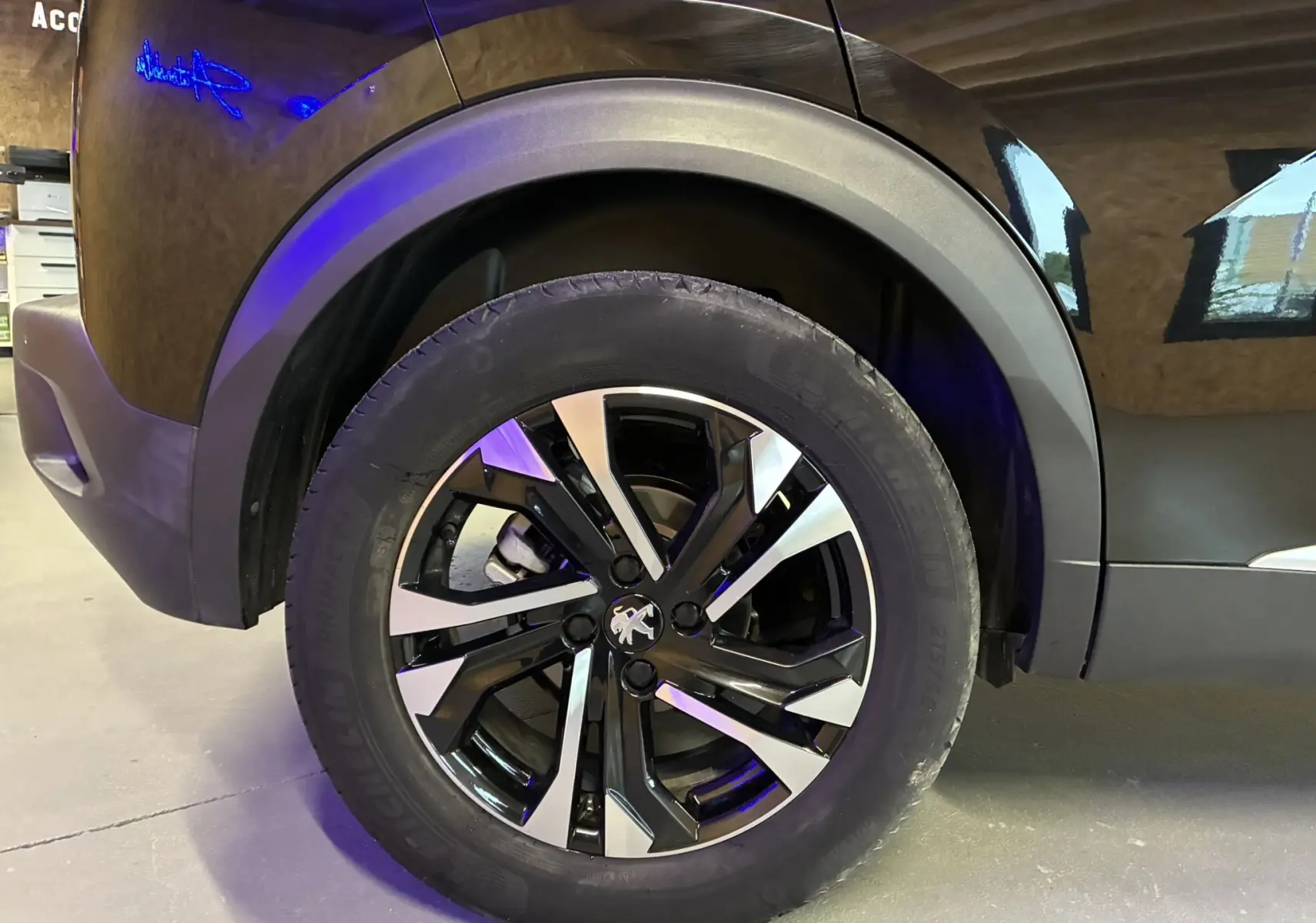 Gros plan sur la roue avant gauche noire du Peugeot 2008 1.5 BlueHDi 130 GT Line avec jante bi-ton distinctive.