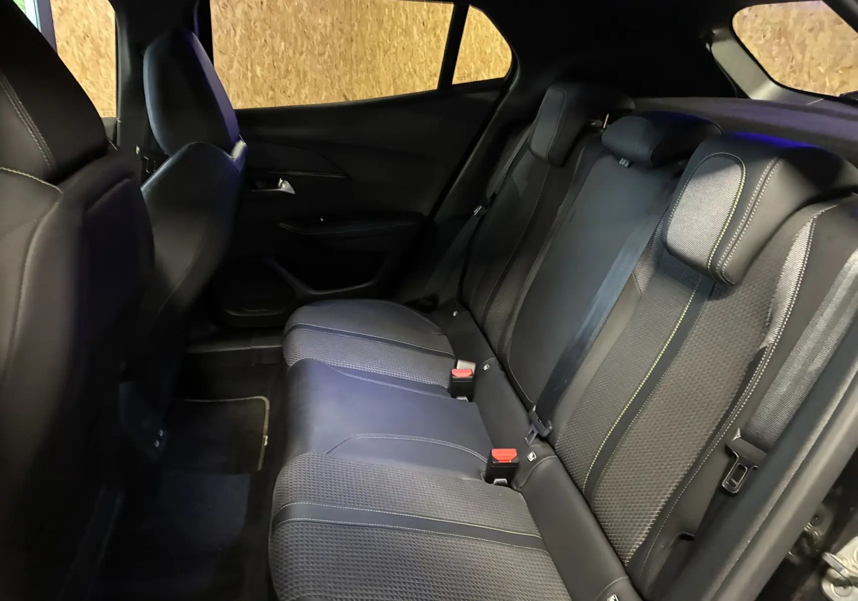 Vue intérieure du siège arrière côté droit du Peugeot 2008 noir, avec sellerie tissu noir et surpiqûres contrastantes.