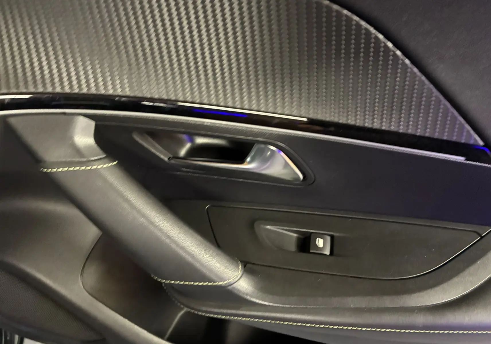 Gros plan sur la garniture intérieure côté gauche de la porte noire du Peugeot 2008 1.5 BlueHDi GT Line 2020.