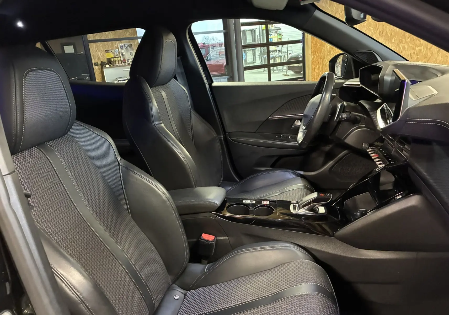 Intérieur noir du Peugeot 2008 1.5 BlueHDi 130 GT Line vu côté gauche, sièges en tissu et cuir avec console centrale moderne.