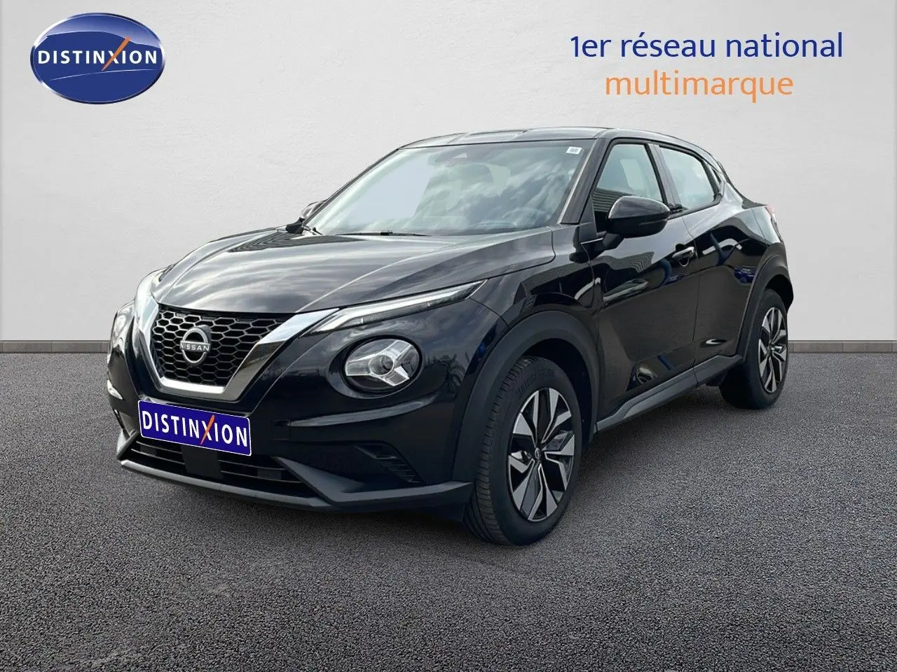 Nissan Juke noir perle métal en 3/4 avant droit, mettant en valeur ses optiques rondes et sa calandre distinctive.