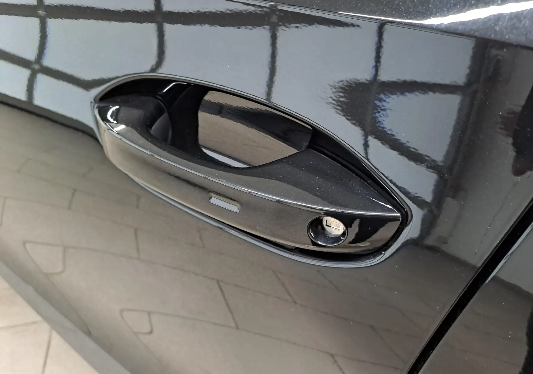 Gros plan sur la poignée de porte côté gauche du CUPRA Formentor 1.4 e-HYBRID noir minuit avec serrure intégrée.