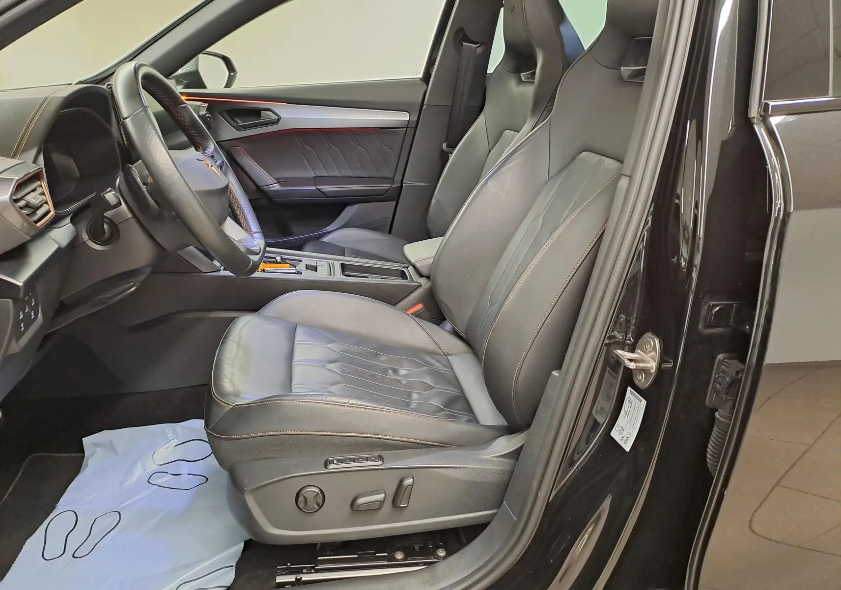 Vue intérieure côté conducteur du CUPRA Formentor 2023 noir minuit, sièges baquets cuir noir avec surpiqûres copper.