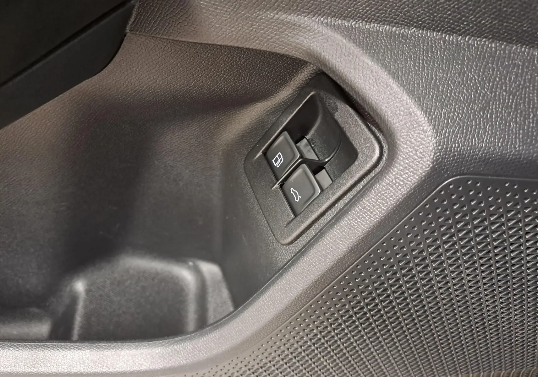 Gros plan sur les boutons d'ouverture du coffre et de la trappe à carburant dans l'habitacle noir du CUPRA Formentor 2023.