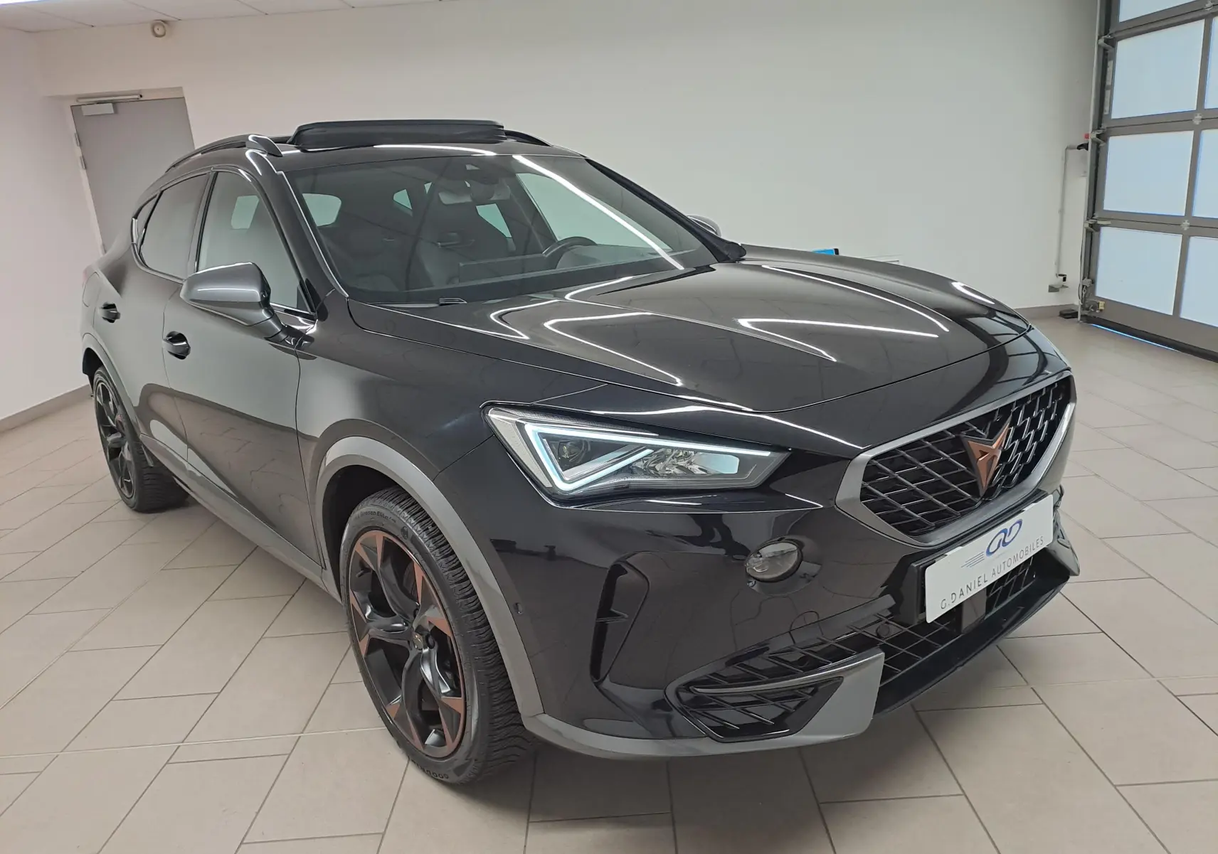 Vue 3/4 avant d'un CUPRA Formentor 1.4 e-HYBRID noir minuit avec jantes noires et toit ouvrant panoramique.