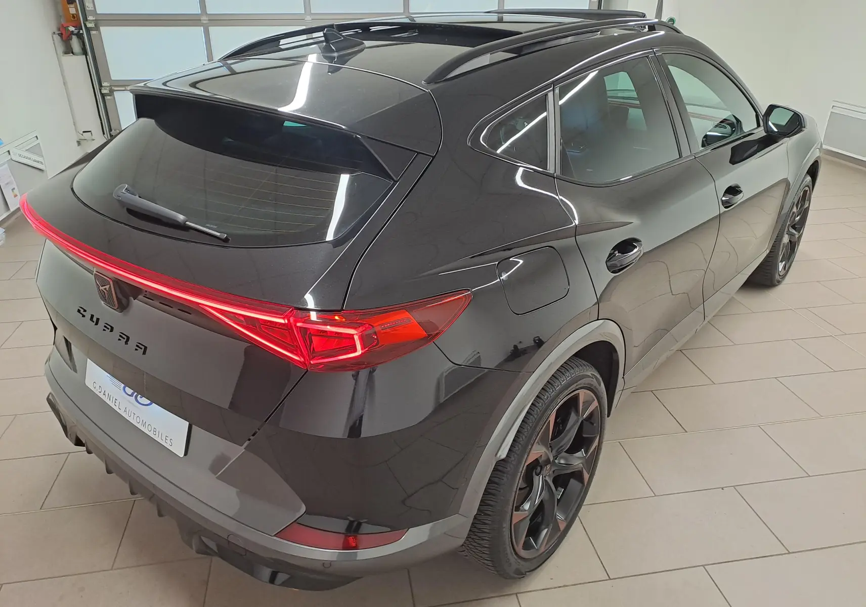 Vue 3/4 arrière droite du CUPRA Formentor noir minuit avec toit ouvrant panoramique et jantes noires 19 pouces.