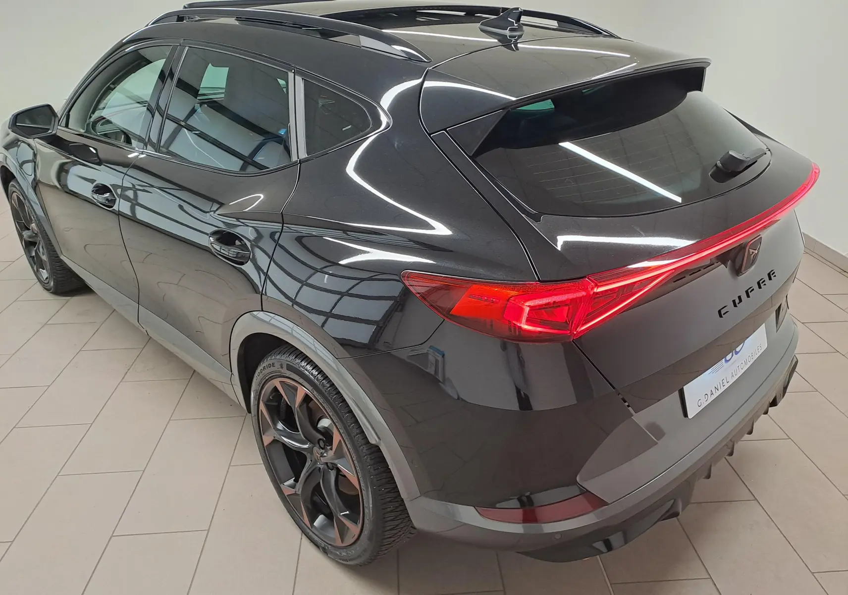 Vue 3/4 arrière droite d'un CUPRA Formentor noir minuit avec jantes 19'' Black Cooper et toit ouvrant panoramique.