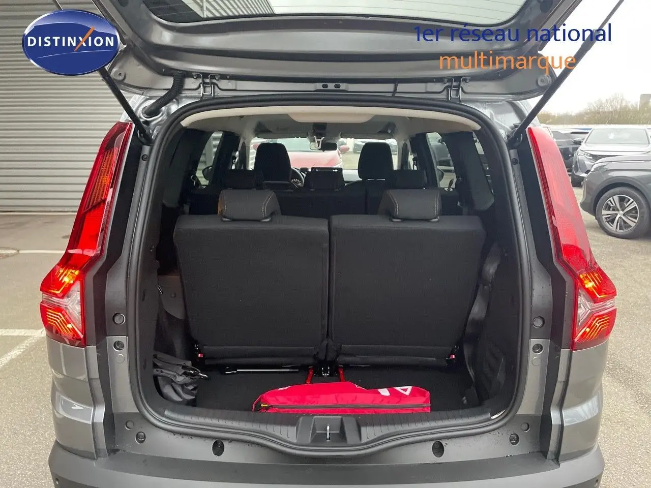 Vue arrière ouverte du Dacia Jogger gris schiste métal, montrant le coffre et les sièges arrière noirs.