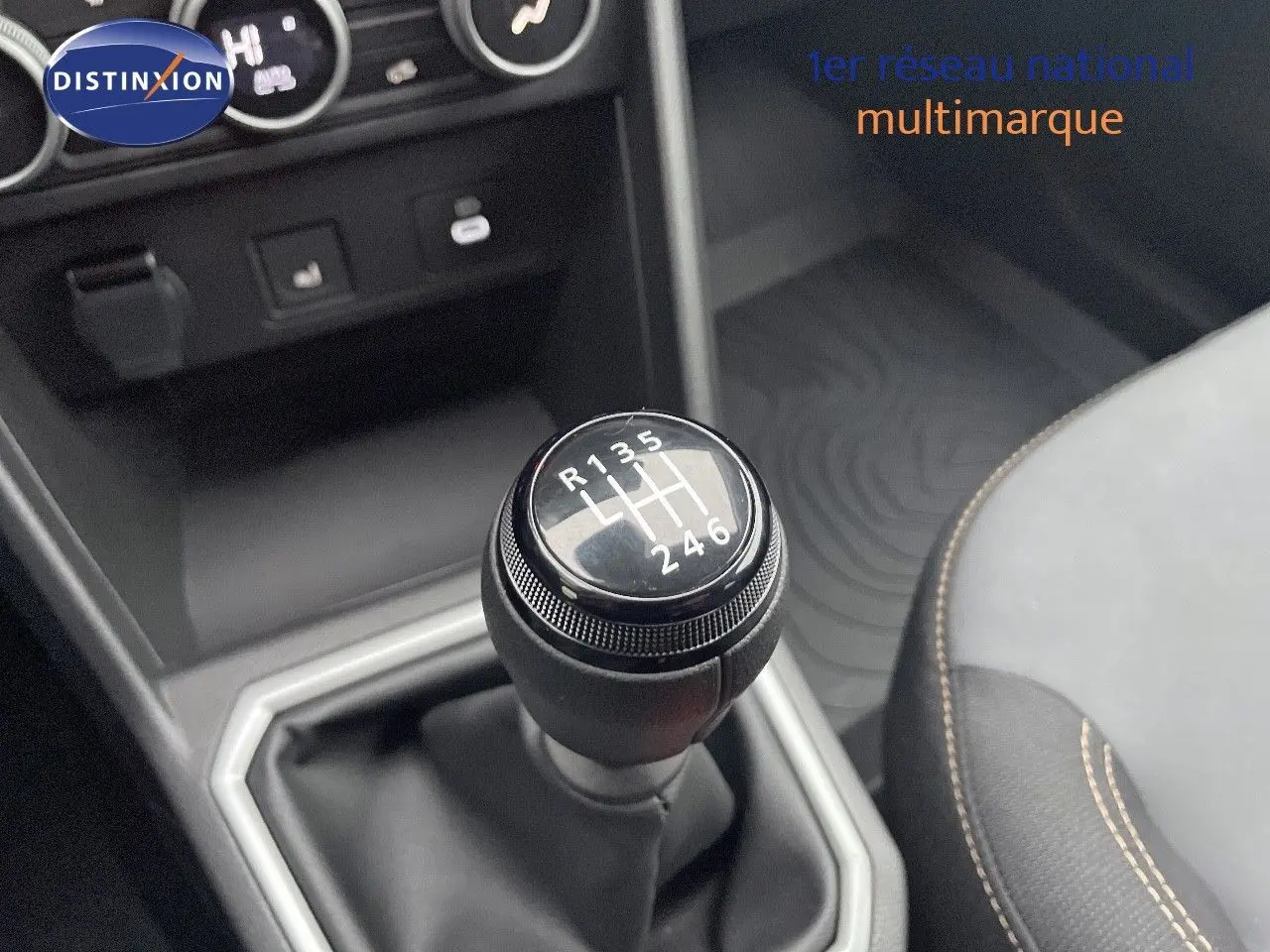 Gros plan sur le levier de vitesses manuel du Dacia Jogger gris schiste, avec coutures apparentes sur le siège adjacent.