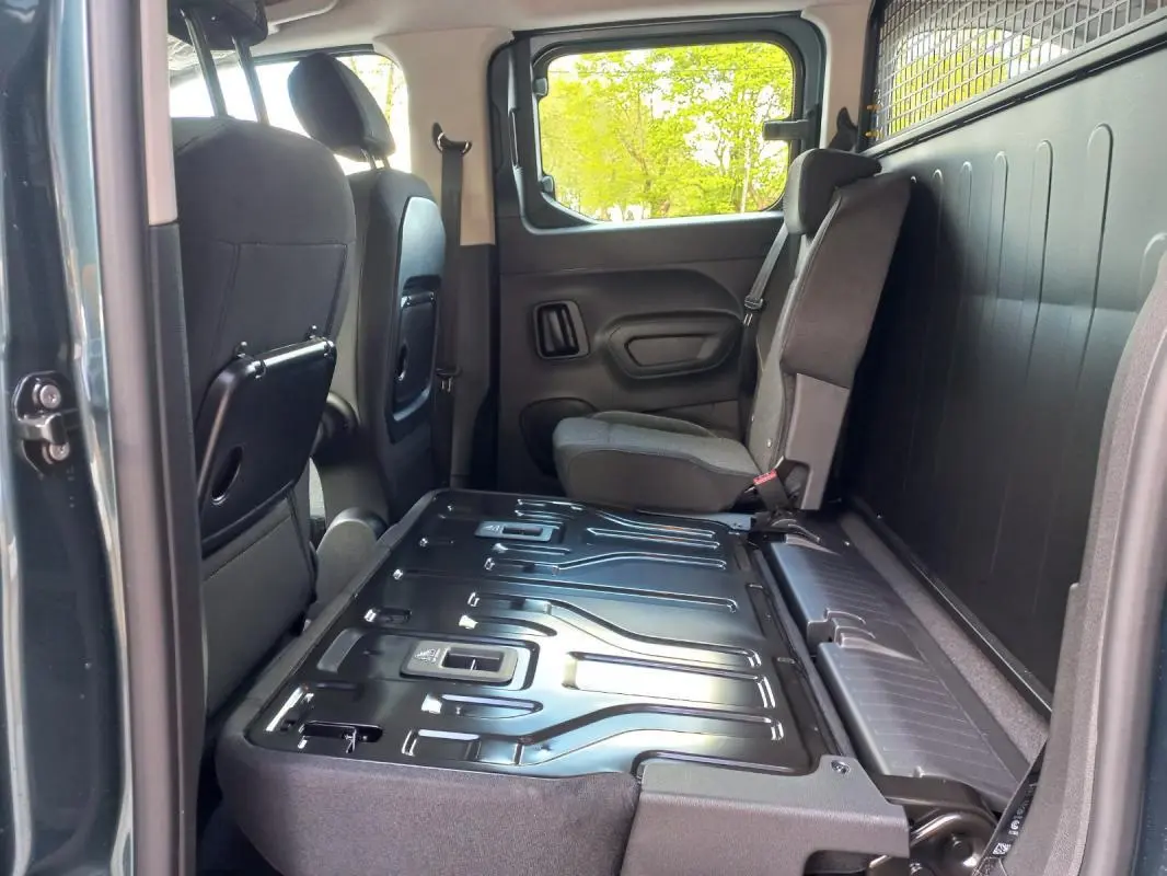 Vue intérieure côté droit de l’Opel Combo Life Elegance M 2025 bleu, montrant la banquette arrière rabattue et les sièges avant.