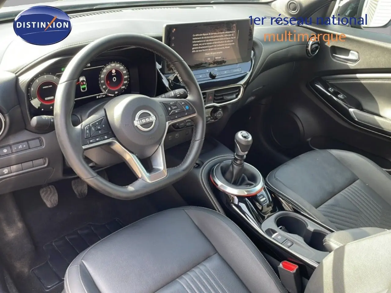 Vue intérieure de la Nissan Juke 2025 DIG-T Tekna, volant cuir, tableau de bord digital et levier de vitesse manuel.