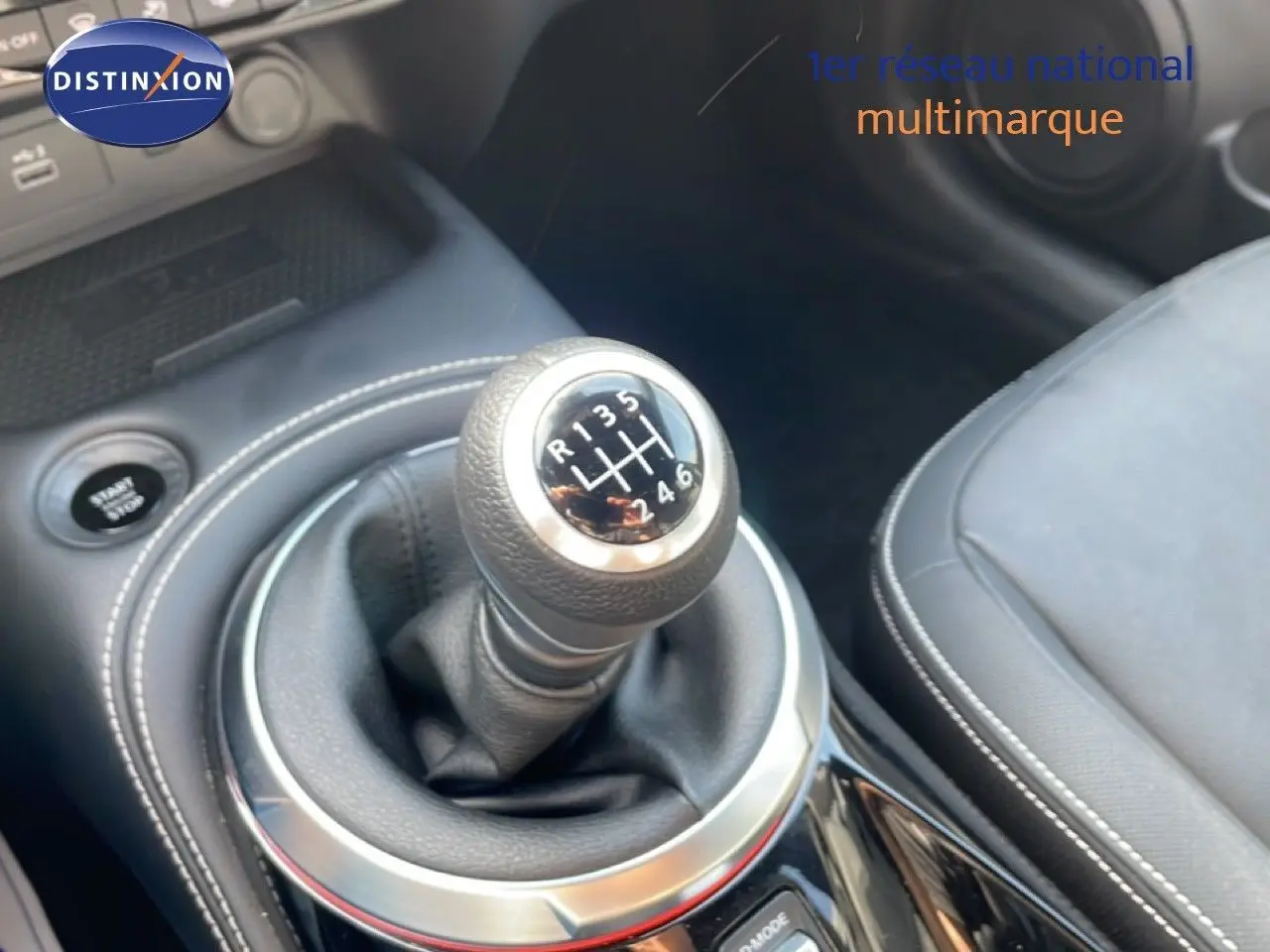 Gros plan sur le levier de vitesses manuel du Nissan Juke 2025 noir Kuro Metal, avec coutures blanches et sellerie cuir noire.