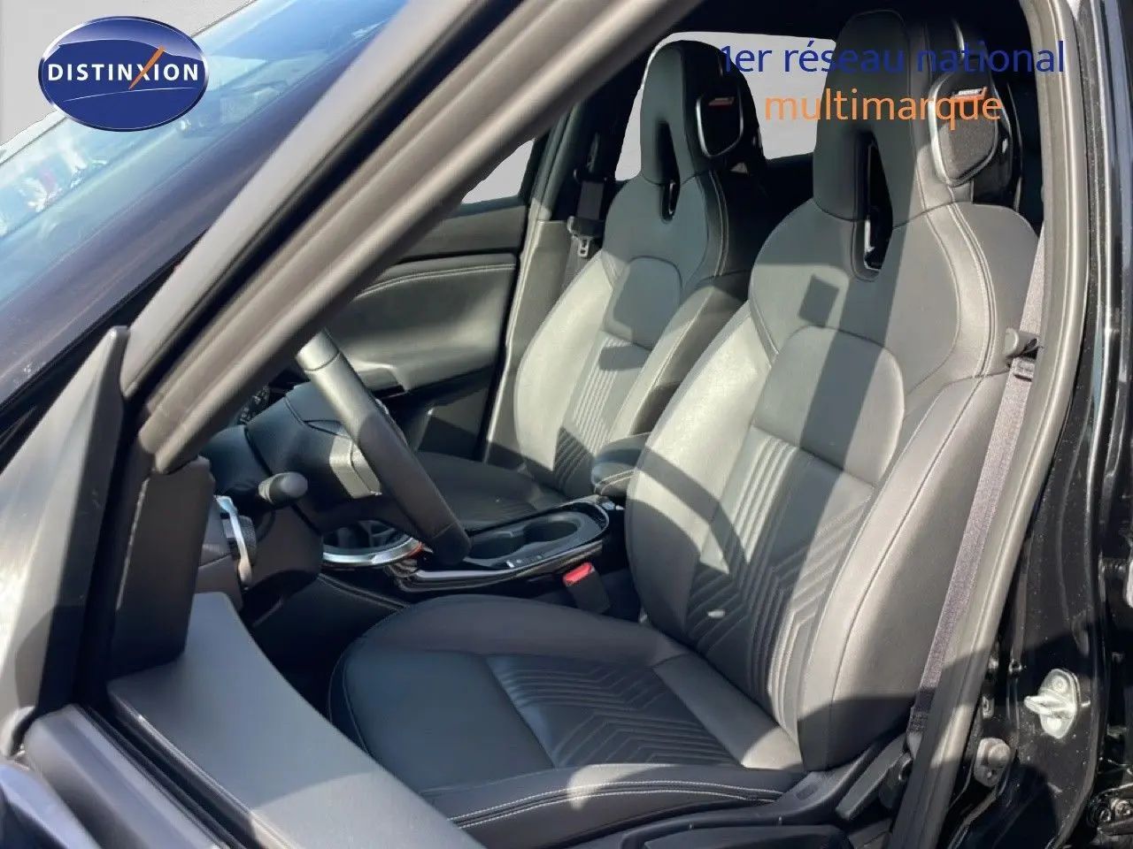 Vue intérieure côté gauche du Nissan Juke 2025 noir Kuro Metal, mettant en valeur les sièges en cuir et le volant multifonction.