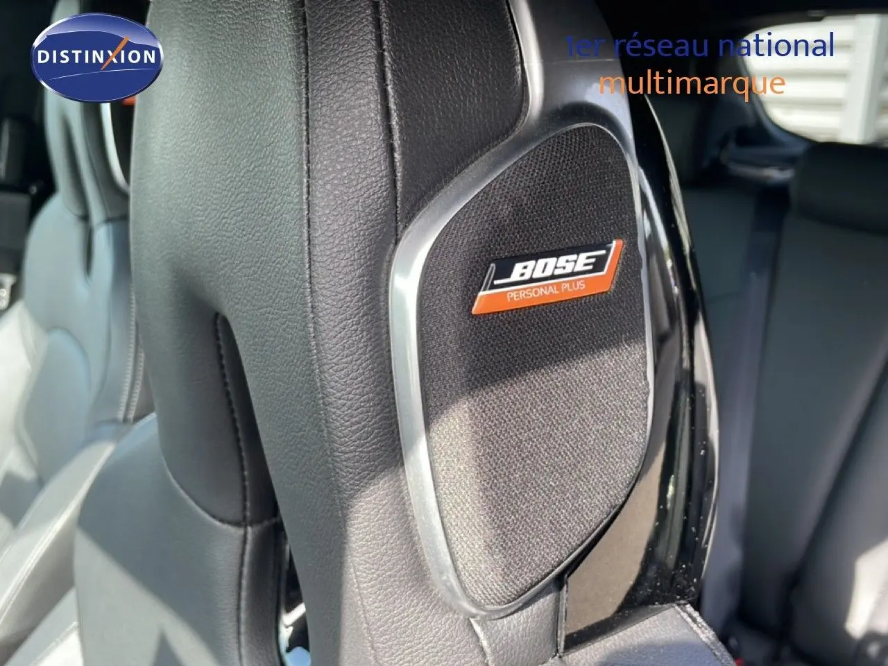 Gros plan sur l’enceinte Bose intégrée au dossier en cuir noir du siège avant d’un Nissan Juke 2025.