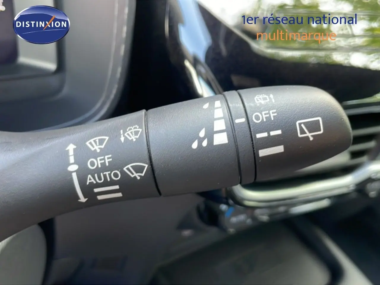 Gros plan sur la commande d’essuie-glace du Nissan Juke noir Kuro Metal, intérieur moderne avec détails blancs.