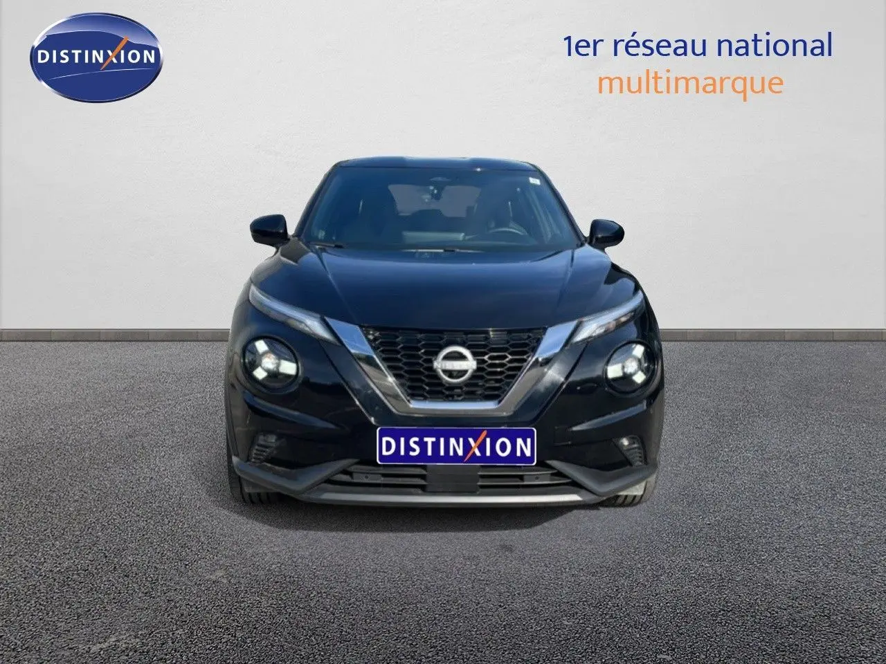 Vue de face d'un Nissan Juke 2025 noir Kuro Metal avec calandre chromée et phares LED allumés.