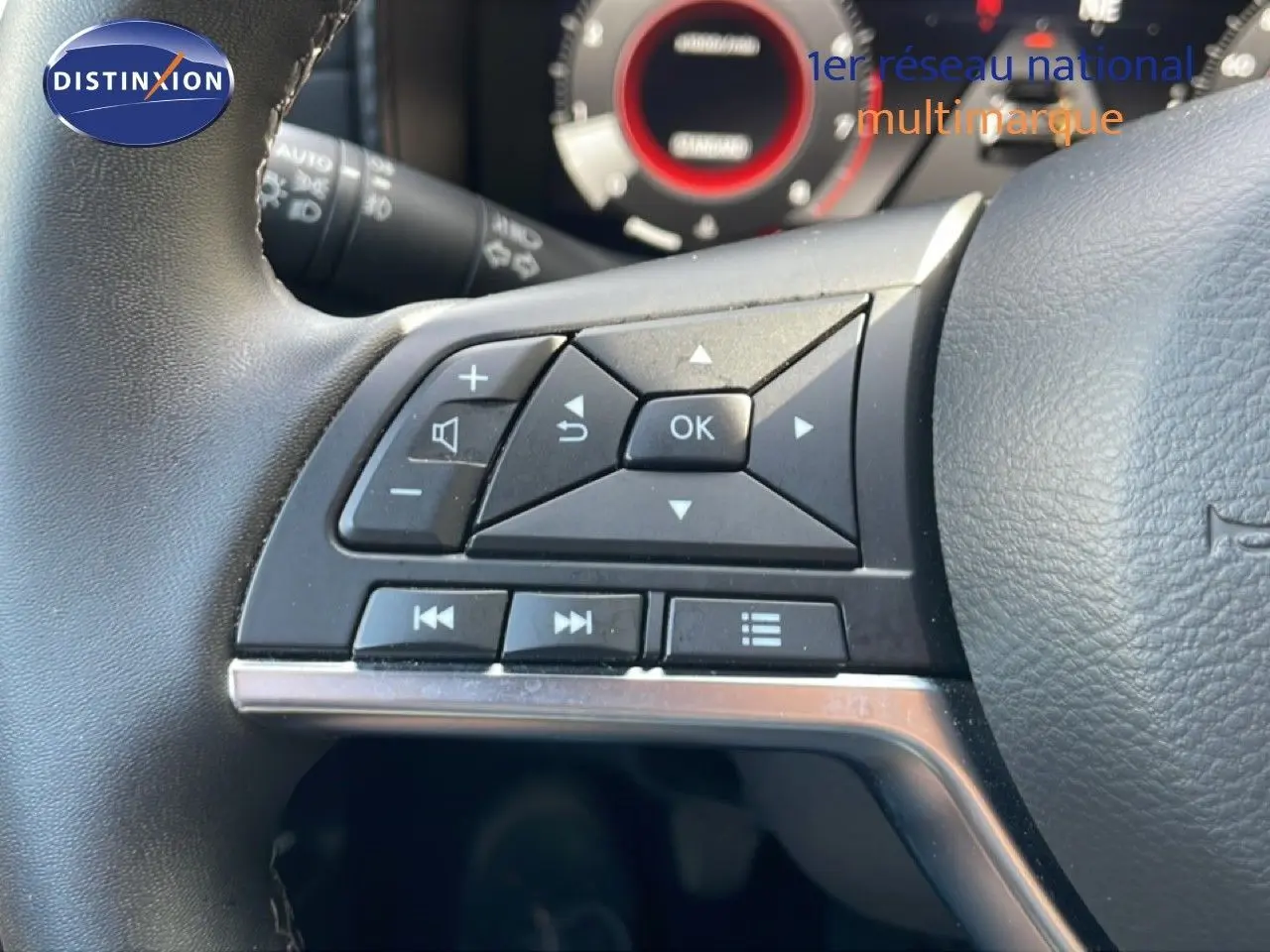 Gros plan sur les commandes multifonctions côté gauche du volant noir du Nissan Juke 2025, finition Tekna.