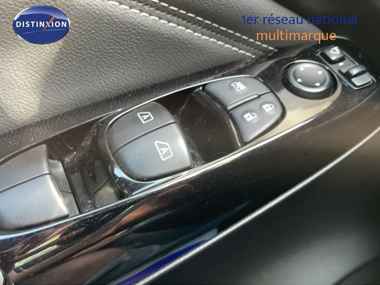 Gros plan sur les commandes des vitres et rétroviseurs côté conducteur du Nissan Juke noir Kuro Metal 2025.