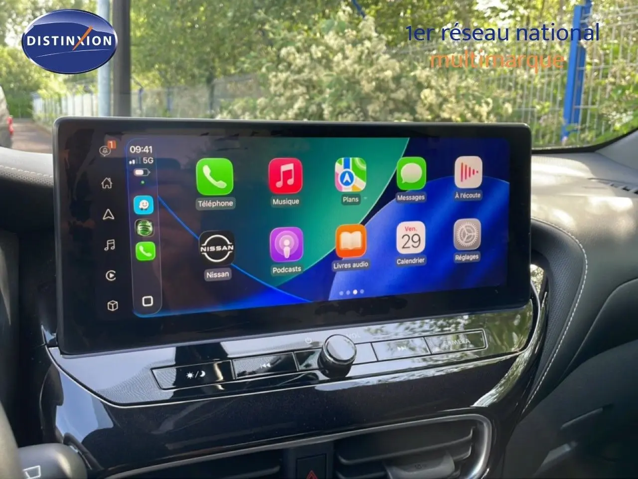 Vue intérieure centrée sur l'écran tactile du tableau de bord du Nissan Juke 2025 noir, affichant les applications connectées.