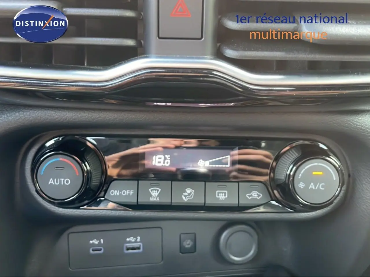Gros plan sur la console de climatisation digitale du Nissan Juke noir Kuro Metal, affichant 18,6°C et commandes tactiles.