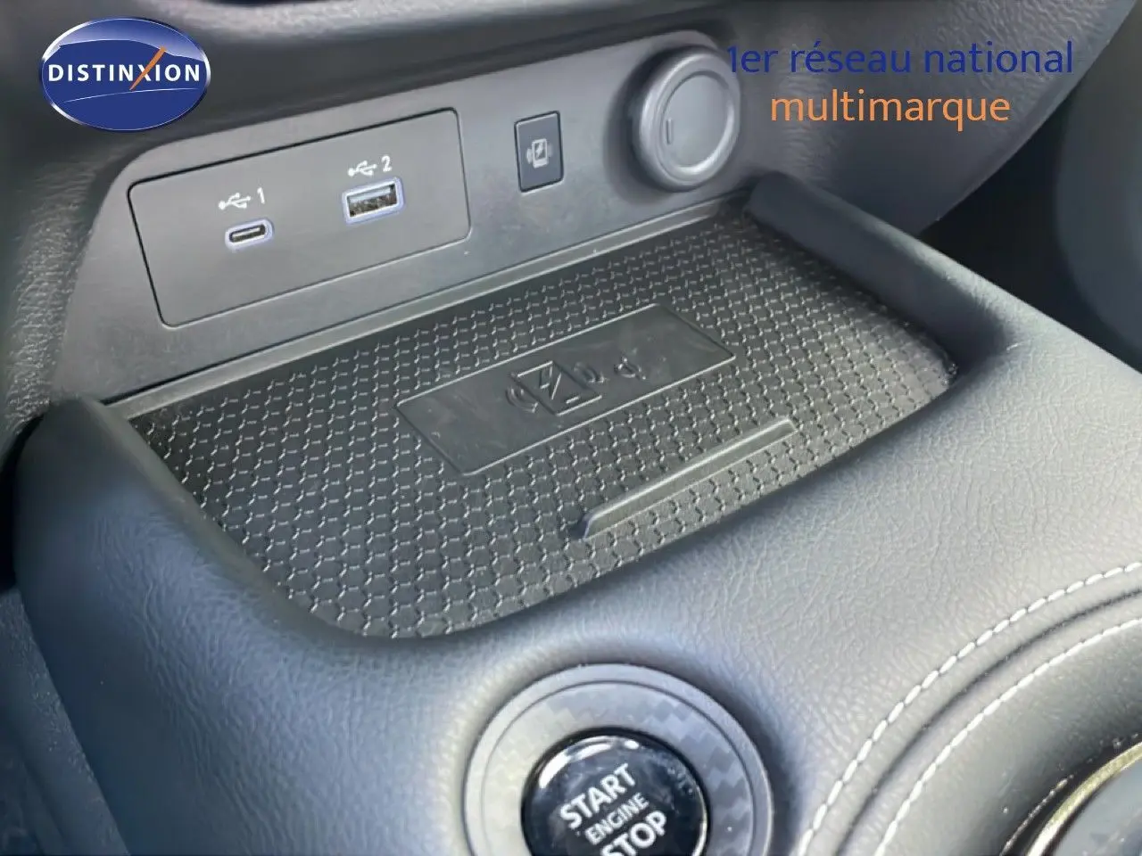 Gros plan sur la console centrale du Nissan Juke noir Kuro Metal, montrant le bouton start/stop et les ports USB.