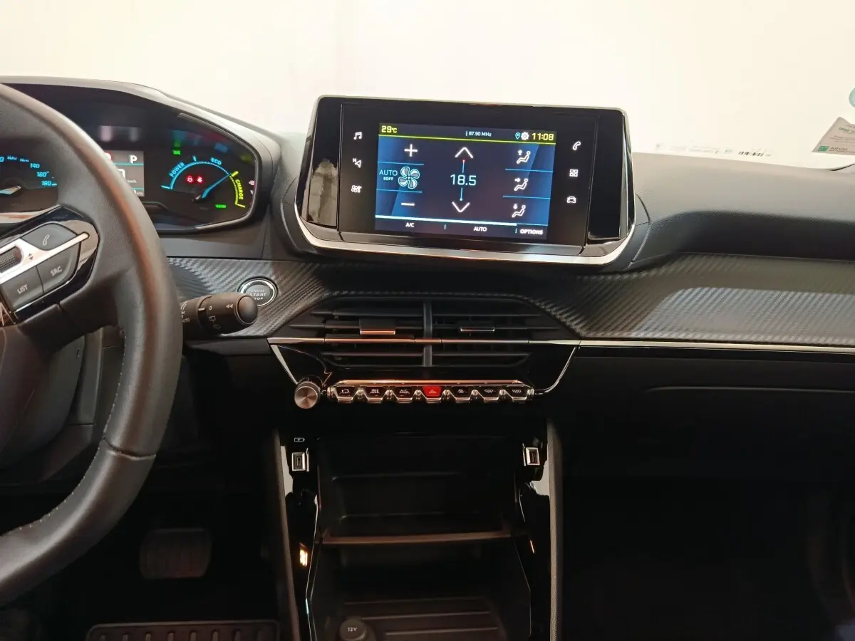 Vue intérieure du tableau de bord de la Peugeot E-2008 électrique Active Pack 2023 avec écran tactile et volant cuir noir.