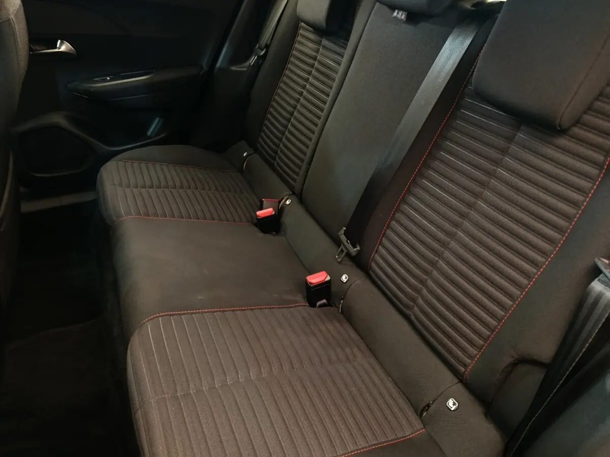 Vue rapprochée de la banquette arrière noire avec surpiqûres rouges du Peugeot E-2008 Electrique Active Pack 2023.