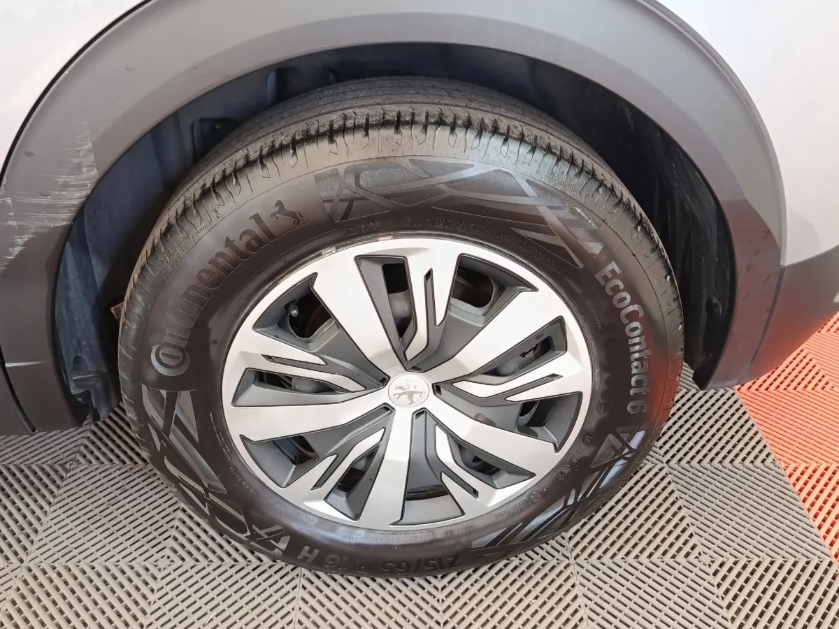 Gros plan sur la roue avant droite gris clair du Peugeot E-2008 électrique avec jante spécifique et pneu Continental.