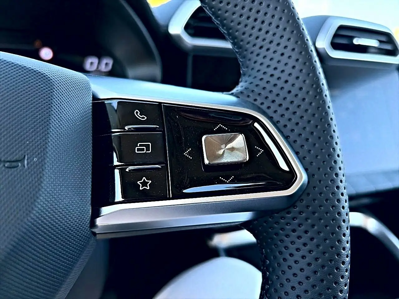 Gros plan sur les commandes noires et argentées du volant perforé côté gauche du MG Motor ZS hybride noir 2026.