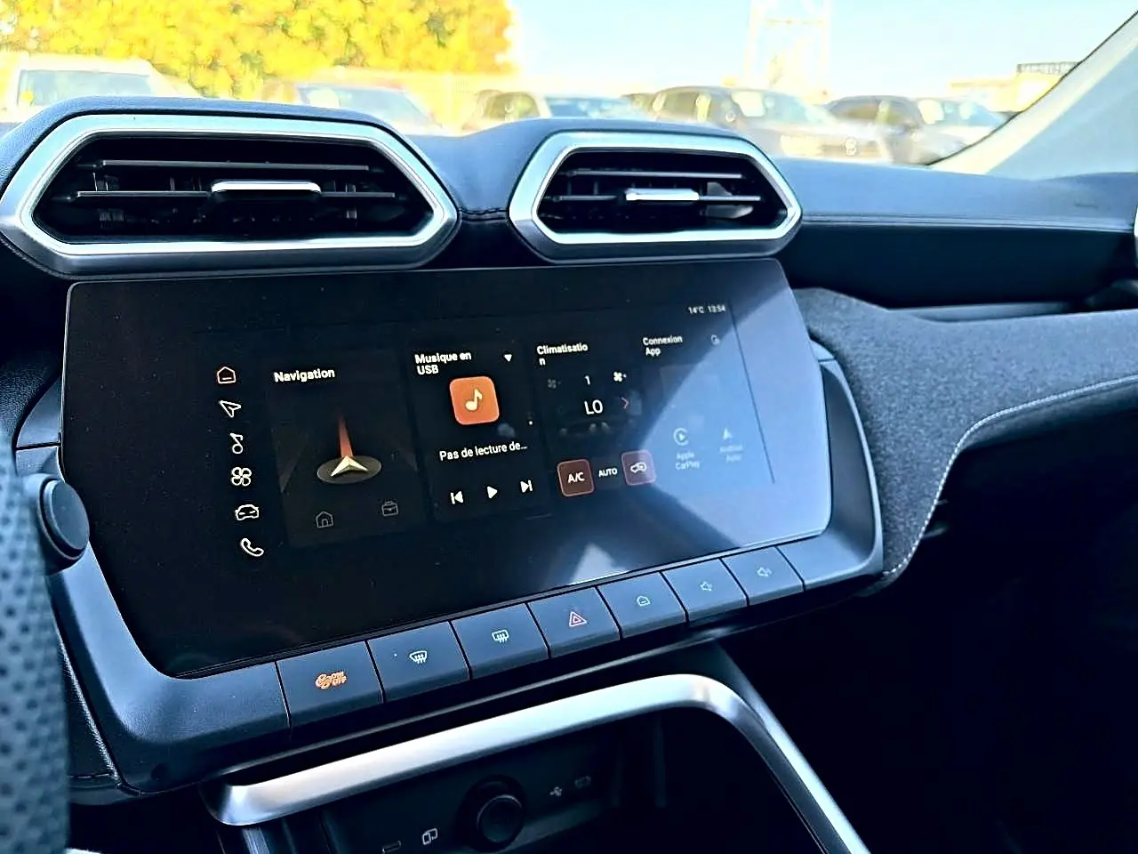 Vue rapprochée de la console centrale du MG Motor ZS hybride 2026, écran tactile et aérateurs hexagonaux noirs.