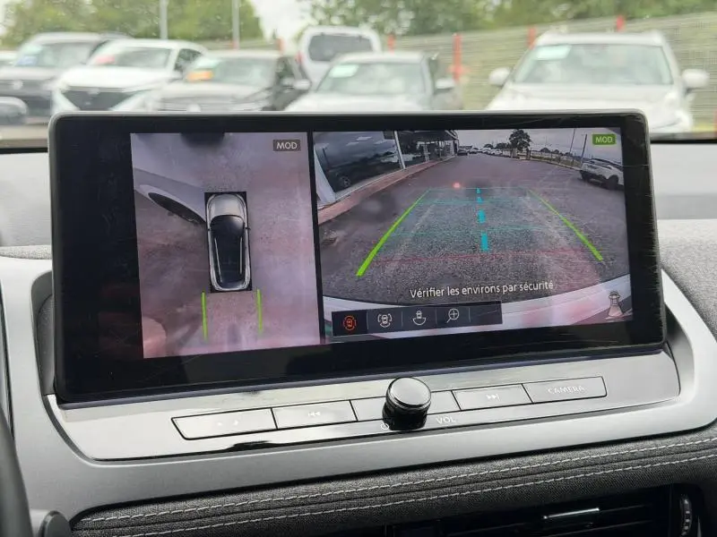 Écran tactile intérieur montrant la caméra de recul et vue 360° du Nissan Qashqai blanc nacré, tableau de bord moderne.