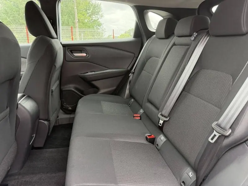 Vue intérieure côté droit de la banquette arrière noire du Nissan Qashqai 2025, sièges tissu mixte TEP.