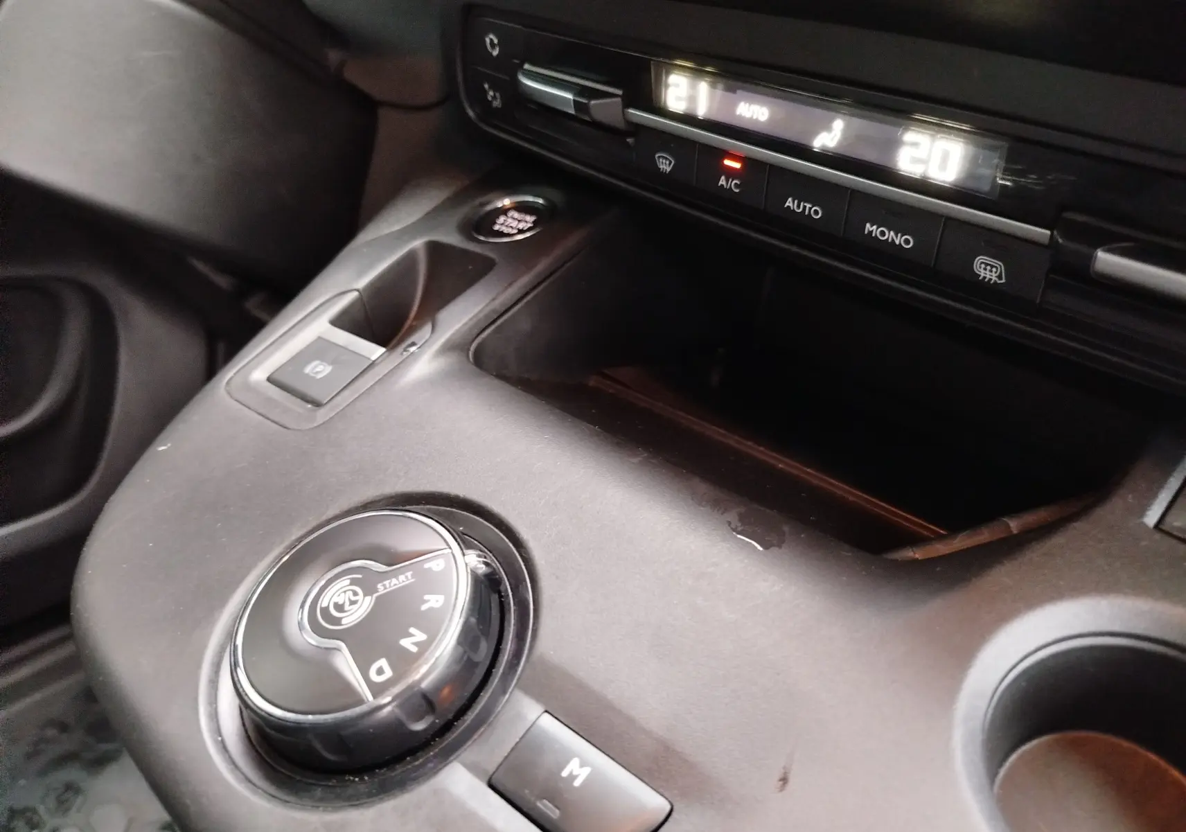 Gros plan sur la console centrale du Peugeot Partner 2020 gris foncé, montrant la molette de boîte auto et les commandes de climatisation.