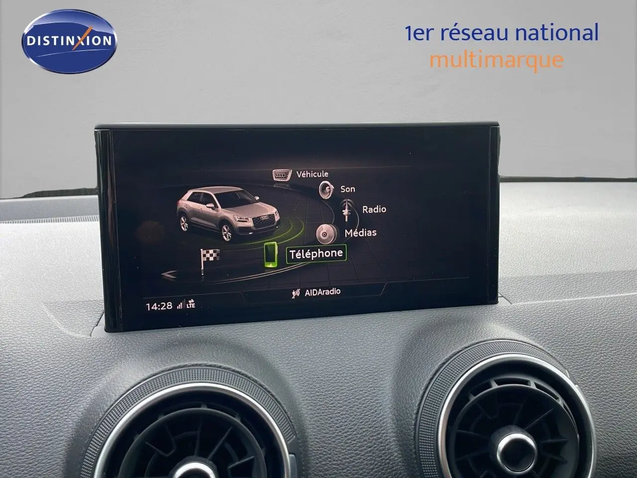 Écran central affichant le menu multimédia de l'Audi Q2 35 TFSI 2023, tableau de bord gris clair.