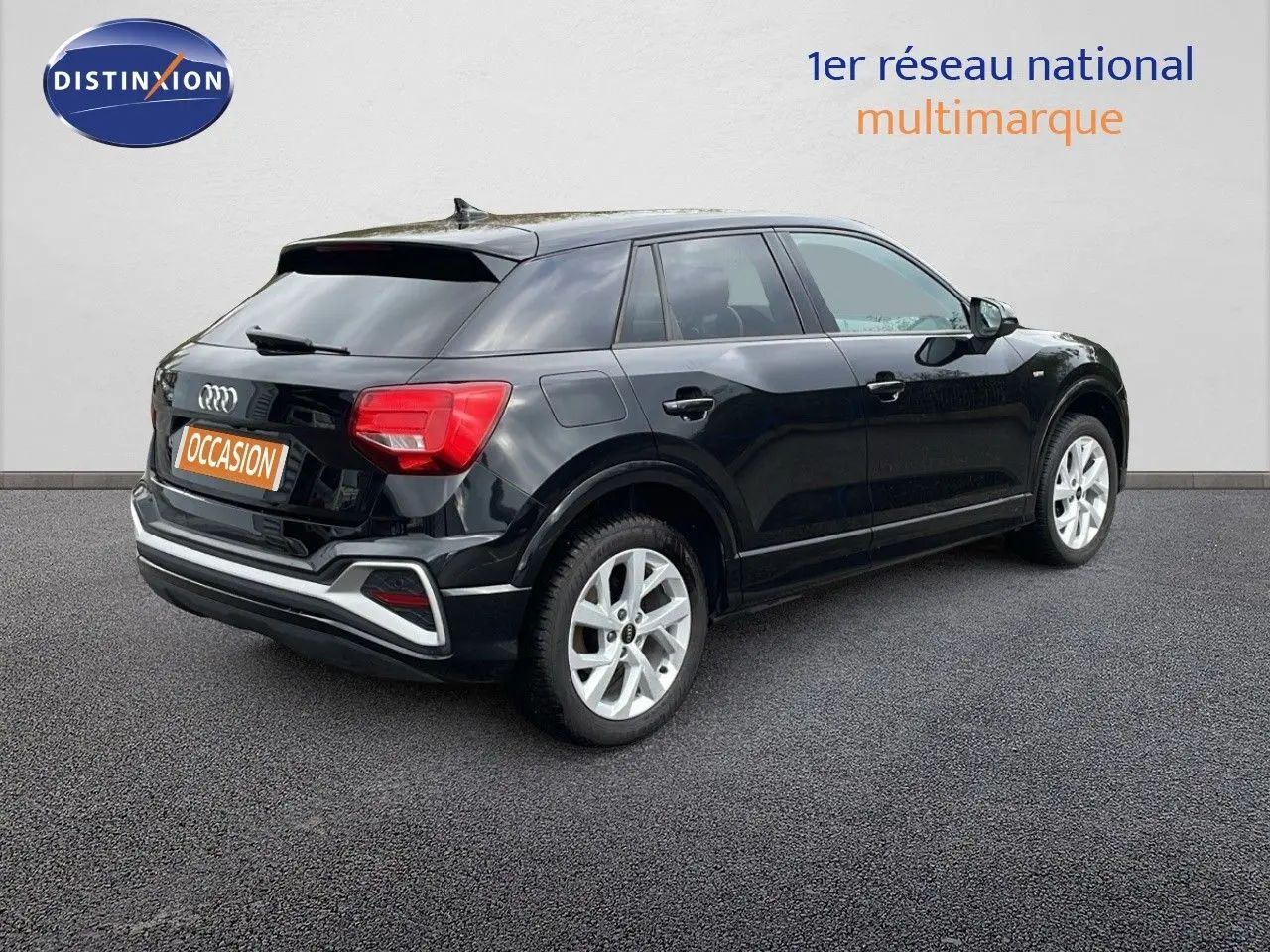 Audi Q2 noir mito metal vue 3/4 arrière côté droit, avec jantes argentées et feux arrière rouges.