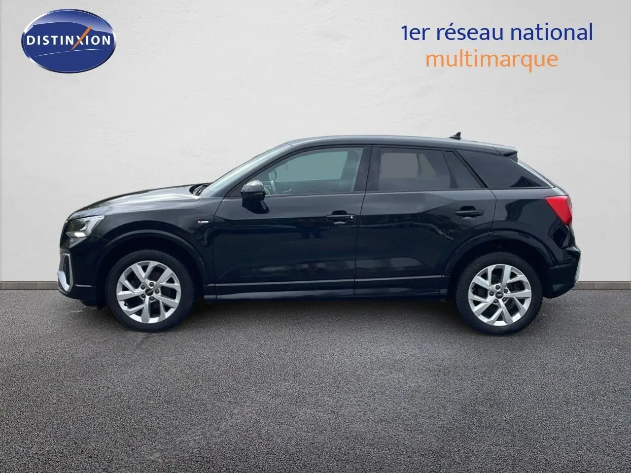 Profil côté gauche d'un Audi Q2 noir mito metal 2023, finition S-Line avec jantes alliage et lignes épurées.