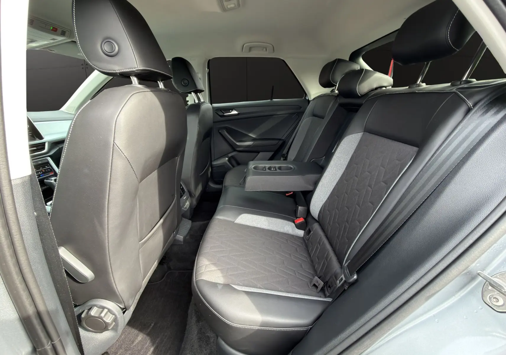 Vue intérieure côté droit des sièges arrière noirs et gris avec accoudoir central déployé du Volkswagen T-Roc 2025.