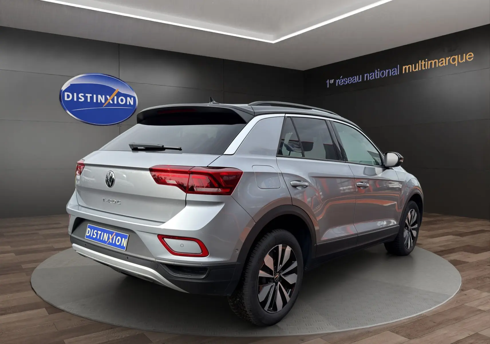 Volkswagen T-Roc gris Pyrite avec toit noir, vue 3/4 arrière droit, attelage amovible visible, jantes alu 17 pouces.