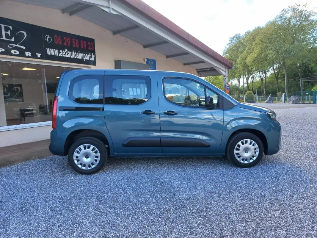 Vue de profil côté droit d'un Opel Combo Life bleu 2025 avec portes coulissantes et jantes acier argentées.