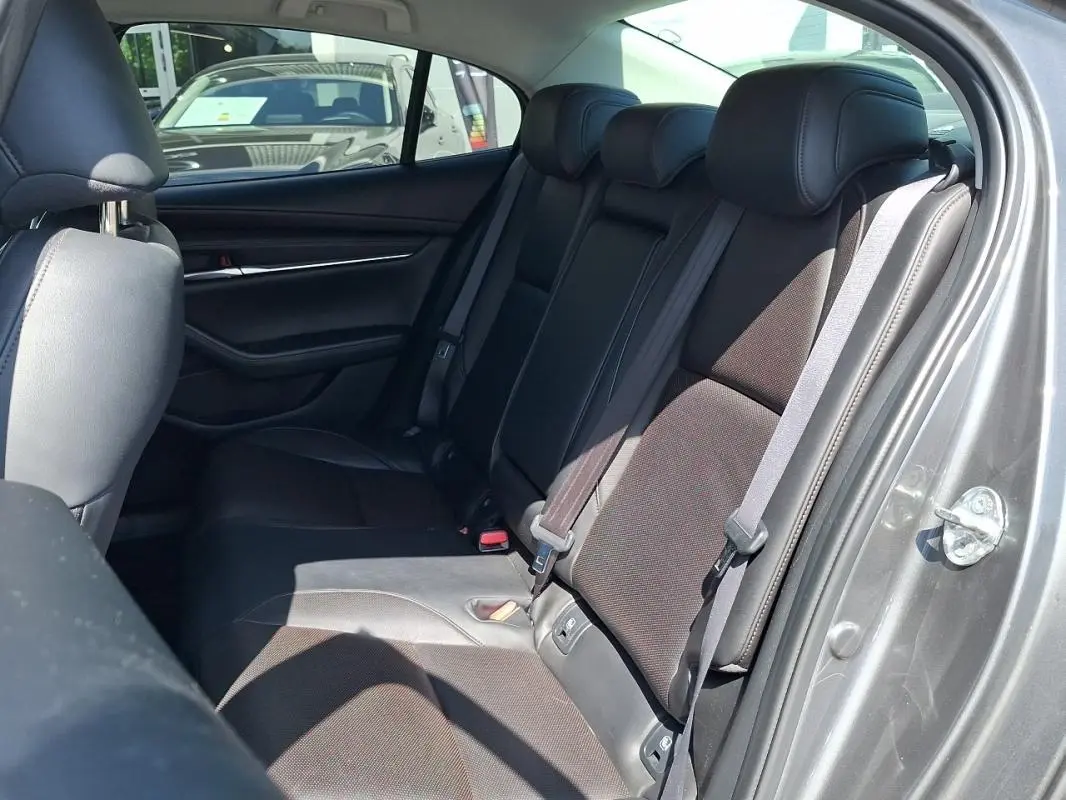 Vue intérieure côté droit des sièges arrière en cuir noir d'une Mazda3 gris 2020, avec ceinture de sécurité visible.
