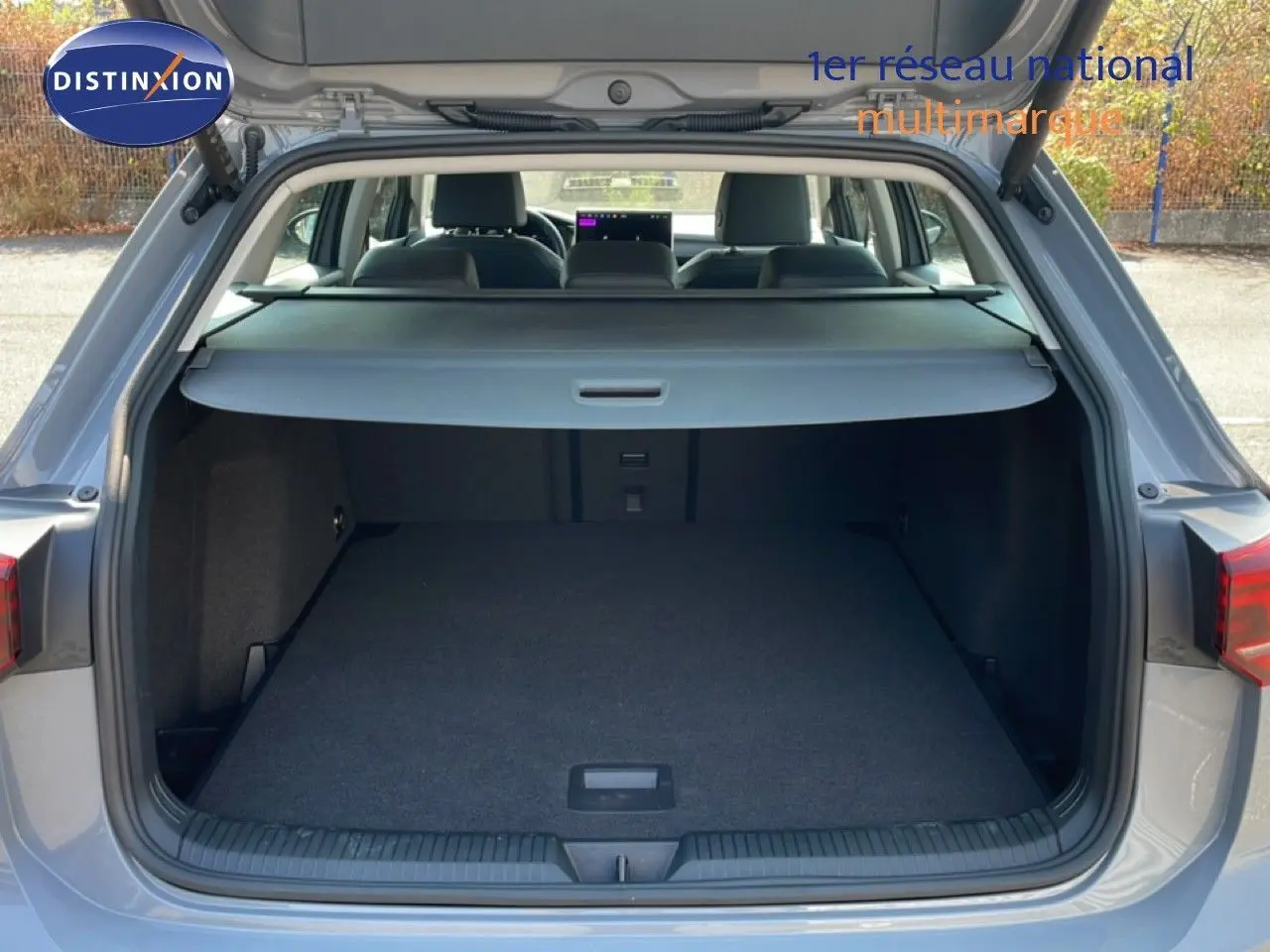 Coffre ouvert d'une Volkswagen Golf SW gris lunaire métal, vue arrière montrant l'espace de chargement et la plage arrière.