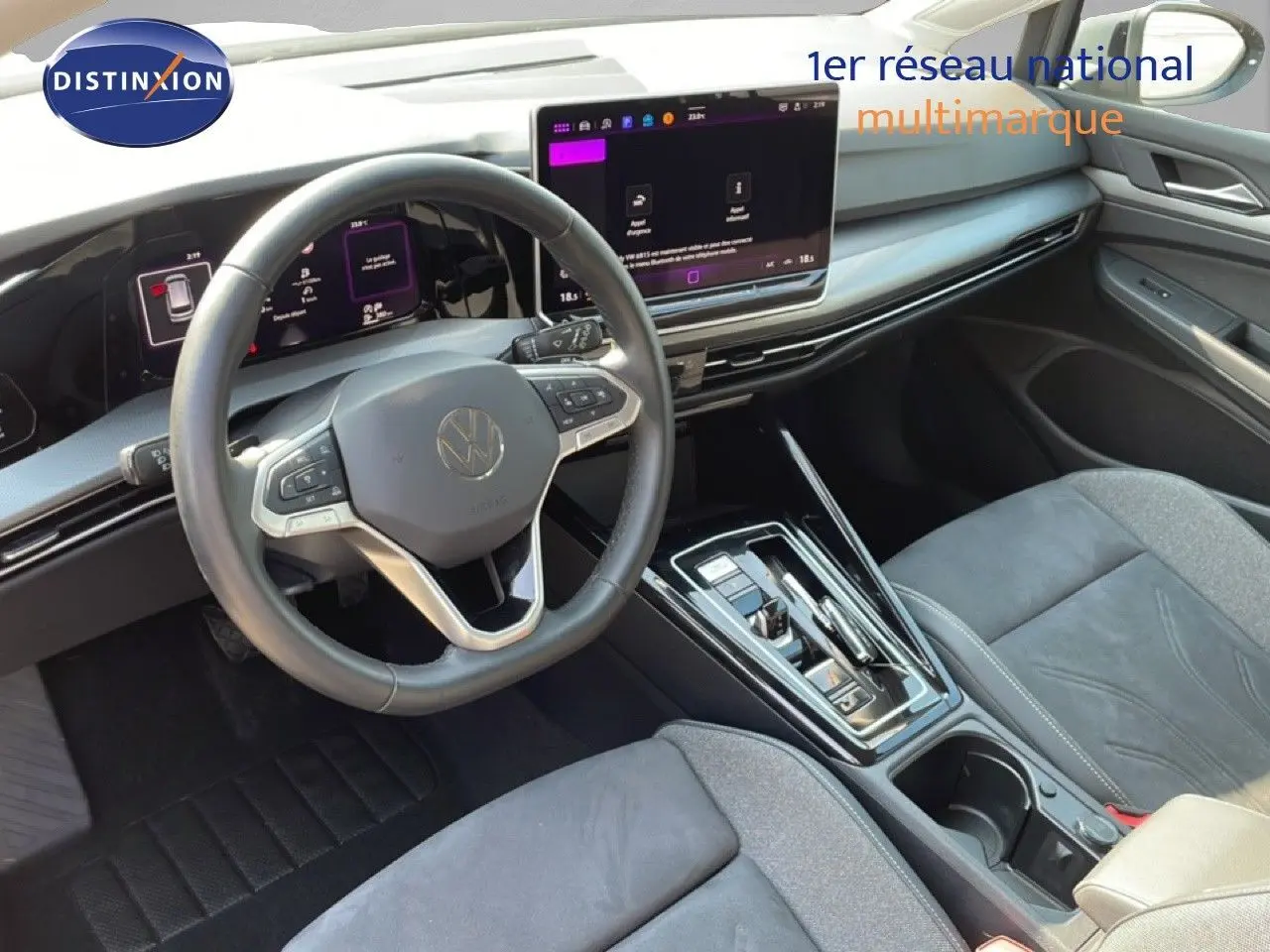 Vue intérieure côté conducteur de la Volkswagen Golf SW VIII 2024, tableau de bord moderne avec écran tactile et volant cuir gris.