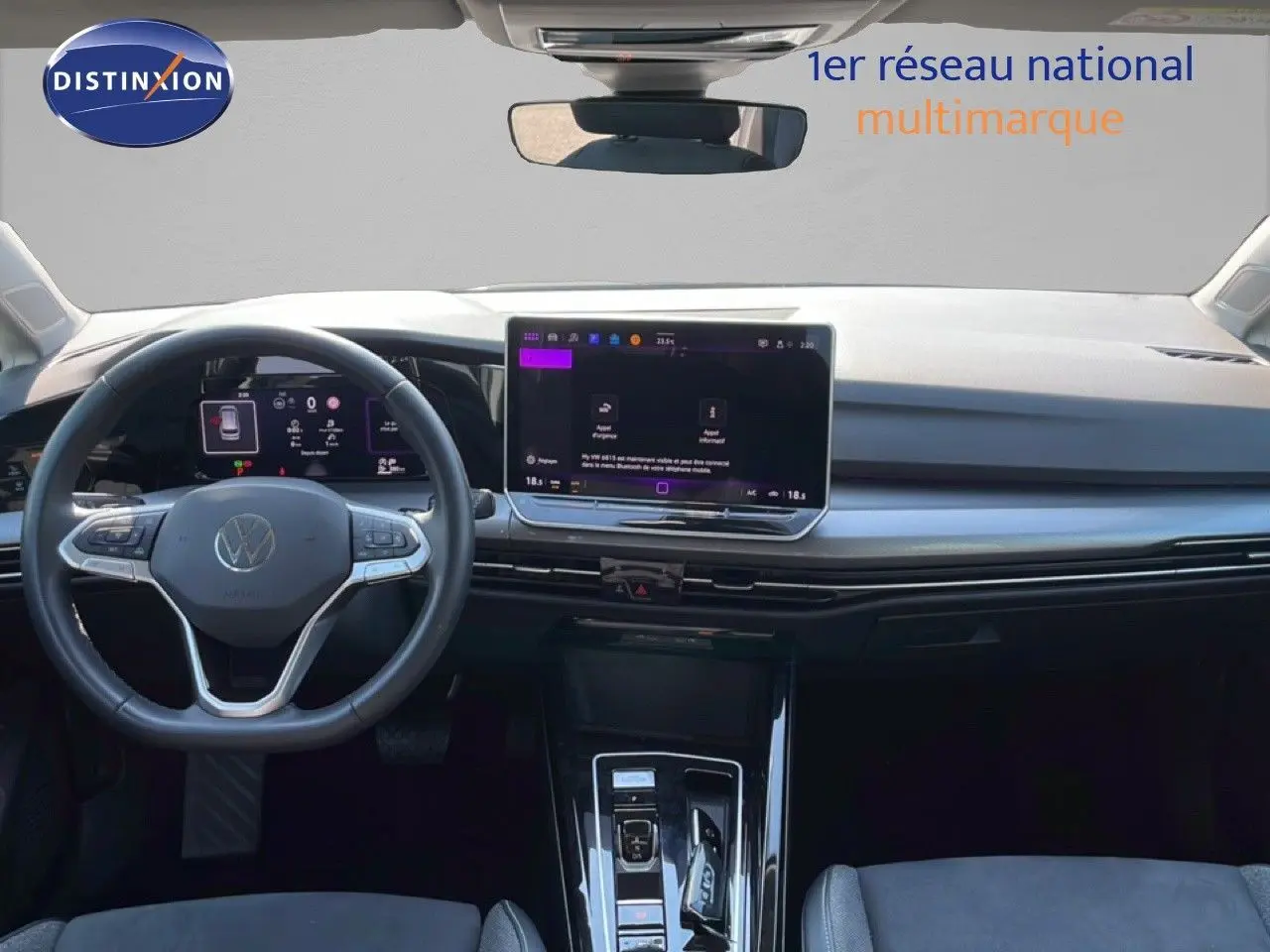 Vue intérieure frontale du tableau de bord et volant gris d'une Volkswagen Golf SW VIII 2024 avec écran tactile central.