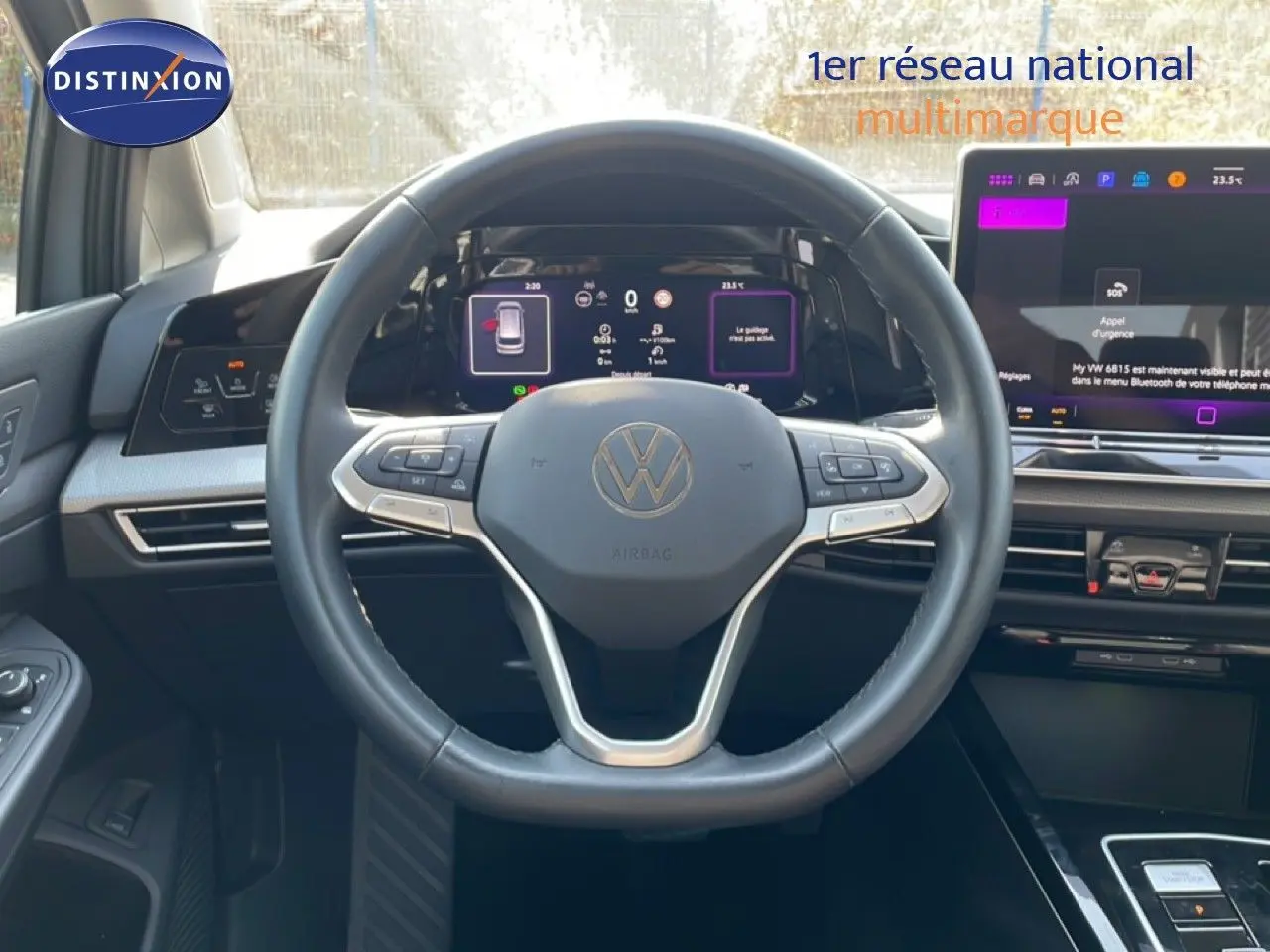Vue intérieure centrée sur le volant cuir noir et les écrans digitaux du tableau de bord de la Volkswagen Golf SW gris lunaire.