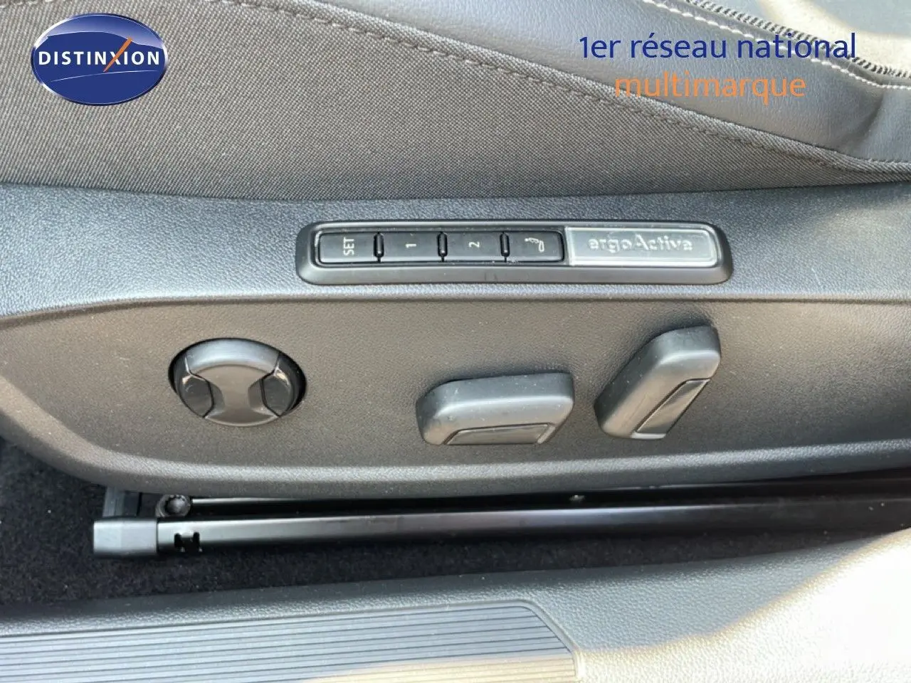 Gros plan sur les commandes de réglage électrique du siège conducteur d'une Volkswagen Golf SW gris lunaire 2024.