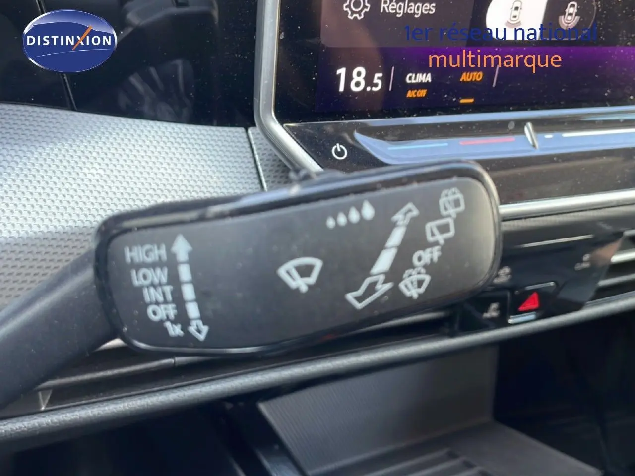 Gros plan sur la commande d’essuie-glace dans l’habitacle gris noir d’une Volkswagen Golf SW VIII 2024, tableau de bord en arrière-plan.