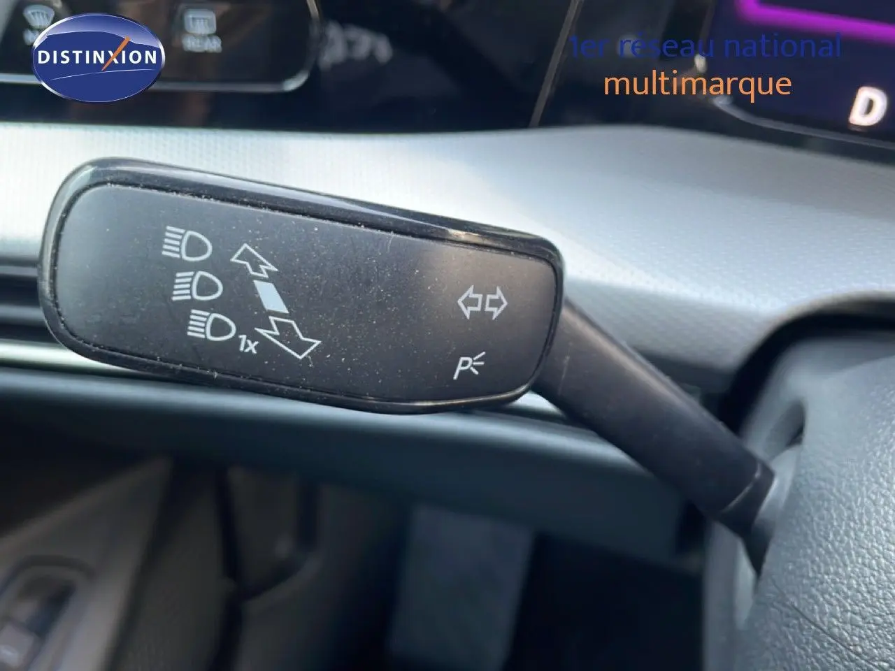 Gros plan sur la commande de clignotant à gauche du volant d'une Volkswagen Golf SW VIII gris lunaire 2024.