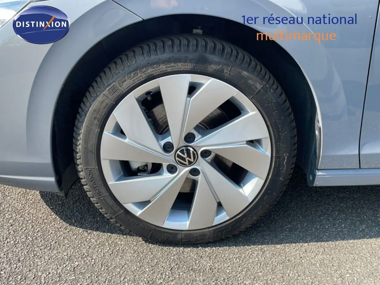 Gros plan sur la roue avant droite d'une Volkswagen Golf SW gris lunaire métal avec jante alu distinctive.