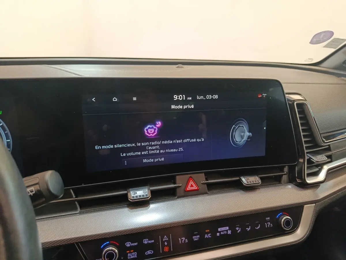 Vue rapprochée du tableau de bord du Kia Sportage gris clair 2022, avec écran tactile central allumé en mode privé.